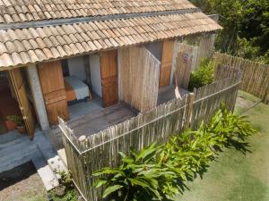 a wooden house with a fence in a yard at Casa Canoa - Praia de Algodões in Marau