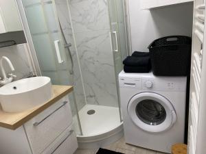 a bathroom with a washing machine and a sink at Le Bohème - Appartement proche gare et commerces in Gisors