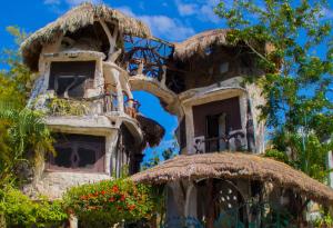 un edificio antiguo con balcones y flores. en La Quinta Orquídea en Puerto Morelos