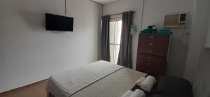 1 dormitorio con 1 cama y TV en la pared en Depto Temporario Centro Corrientes en Corrientes