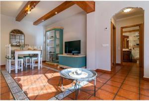 uma sala de estar com uma mesa e uma televisão em Casa Rural Verde Salvia em Arcos de las Salinas