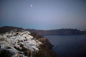 an aerial view of a village on a cliff over water at ArmonOia Suites Santorini in Oia
