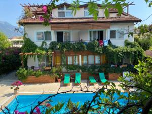 a house with chairs and a pool in front of it at Ten Apart Hotel in Fethiye