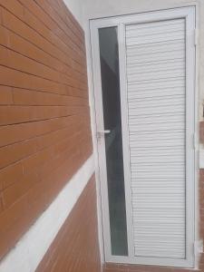 Real Hospedagem في ماناوس: باب زجاجي منزلق على جانب مبنى من الطوب