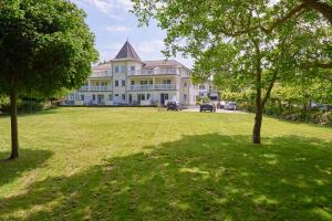 a large house with a large yard with trees at Schlösschen am Schmachter See in Binz