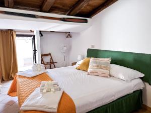 um quarto com uma cama grande e uma cabeceira verde em Calauriia Apartments Marzamemi em Marzamemi