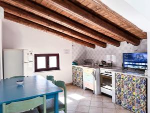 una cucina con tavolo e tavolo da pranzo blu di Calauriia Apartments Marzamemi a Marzamemi
