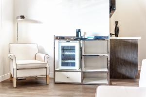 a living room with a chair and a refrigerator at Aspire Inn Studios & Spas in Bellflower