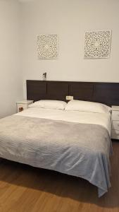 a bedroom with a large bed and two pictures on the wall at Arran de Mar Cambrils in Cambrils