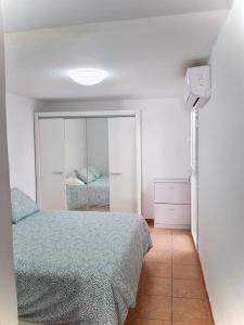 a bedroom with a bed and a mirror at Cozy Apartment With Garden in Puerto Rico de Gran Canaria