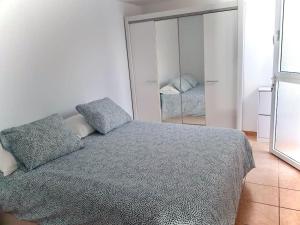a bedroom with a bed and a mirror at Cozy Apartment With Garden in Puerto Rico de Gran Canaria