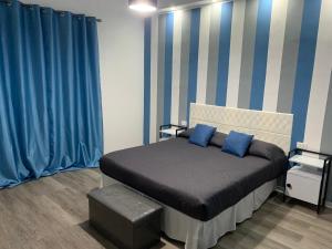 a bedroom with a bed with blue and white stripes at B&B Ramura in Mazara del Vallo