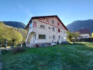 a large house with a grassy yard in front of it at Beau jardin proche randonnée ski calme plain pied in Auzat