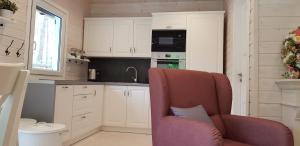 una cocina con armarios blancos y una silla con almohada en Domkiwturawie pl, en Turawa 32 fotos más