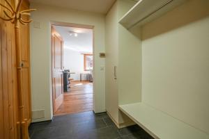 a hallway with white walls and wooden floors at Serenella Apartment in Riederalp
