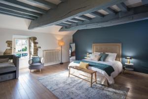 ein Schlafzimmer mit einem großen Bett und einer blauen Wand in der Unterkunft MANOIR DU VAU D ARZ gîtes et chambres d hôtes avec piscine in Malansac