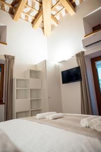 sypialnia z łóżkiem z telewizorem na ścianie w obiekcie Home Dren w mieście Prepotto