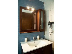 a bathroom with a sink and a mirror at Meteora Olio Hills apartment in Kalabaka