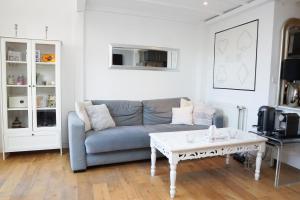 a living room with a couch and a coffee table at EXIGEHOME - Maison Cosy en plein centre de Versailles in Versailles