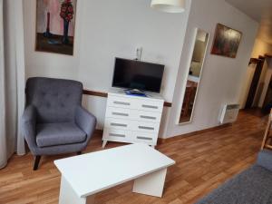 a living room with a chair and a television at Apartamentos Grifovacances Canigou in Pas de la Casa