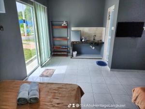 Cette chambre dispose d'une cuisine avec un lit et un évier. dans l'établissement Tok Abu Heritage Roomstay, à Pantai Cenang