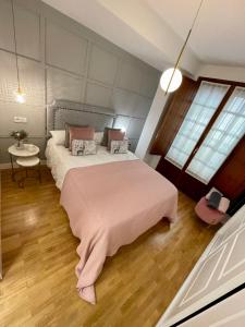 a bedroom with a large bed with a pink blanket at SOL in Oviedo