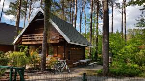 una cabaña en el bosque con una bicicleta aparcada delante en Domkiwturawie pl, en Turawa