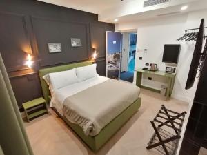 诺拉Hotel XBusiness的一间卧室，配有一张床、一张书桌和一台电视 更多37张照片