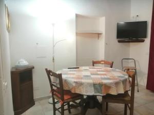 a dining room with a table and chairs and a tv at Casa Serena in Follonica +1 photo