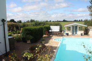 a swimming pool in a yard with a garden at The Owl House with private hot tub in Newport