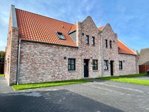 a large brick building with a red roof at Backbord Greetsiel in Krummhörn