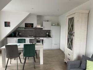 a kitchen with a table and chairs in a room at Backbord Greetsiel in Krummhörn