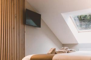 a bedroom with two beds and a flat screen tv on the wall at HOTEL CANDOR in San Salvador