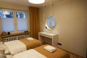 1 dormitorio con 2 camas y espejo en Apartament Wołodyjowskiego, en Białystok