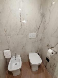 La salle de bains blanche est pourvue de toilettes et d'un lavabo. dans l'établissement Hotel XBusiness, à Nola