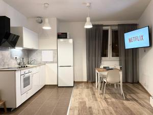 Una cocina con un refrigerador blanco y una mesa. en Rezidence Vackov, en Praga 8 fotos más