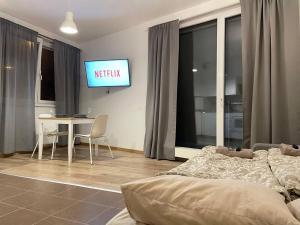 Una sala de estar con una cama y un televisor en la pared. en Rezidence Vackov, en Praga