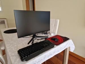 un monitor de ordenador y un teclado y ratón sobre una mesa en Green Park Ajuda Apartment, en Funchal