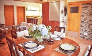 une salle à manger avec une table en bois et des fleurs. dans l'établissement Casa do Caseiro A Costa da Morte, à Jornes