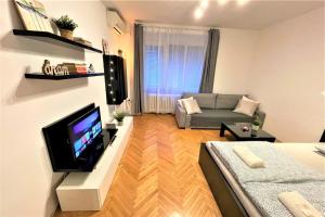 a living room with a couch and a tv at Apartment Helen - Old Town, AC in Bratislava