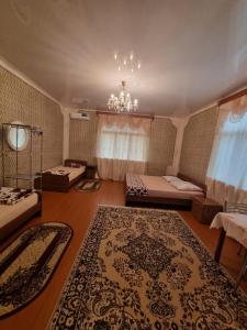 a large room with two beds and a rug at Guesthouse at Oleg's Zolotoy Bereg in Gudauta