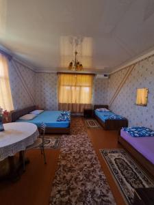 a room with two beds and a table at Guesthouse at Oleg's Zolotoy Bereg in Gudauta