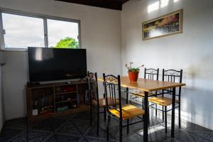 a dining room with a table with chairs and a television at Hermoso apartamento en el centro de Atlántida in Atlántida