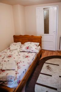 a bedroom with a bed with a wooden frame and a window at Cabana Yvan in Gârda de Sus
