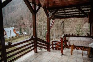 a screened in porch with a table and a view at Cabana Yvan in Gârda de Sus