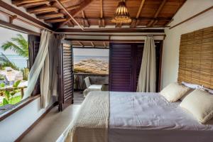 a bedroom with a bed and a view of the ocean at Villa Iamani in Arraial d'Ajuda +114 photos