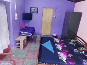 Cette chambre comprend un lit, une table et une porte. dans l'établissement Honey Palace Homestay, à Madikeri