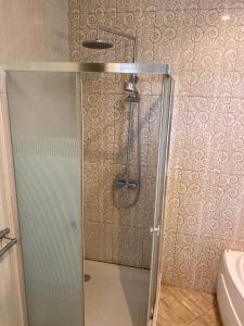 a shower with a glass door in a bathroom at Omah Ngangeni by OTSCA in Ngabean