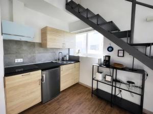a kitchen with wooden cabinets and a black staircase at Azur Arts Lanzarote Lofts in Tinajo