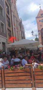 um grupo de pessoas sentadas em um restaurante sob um guarda-chuva em Apartament Elbląg Stare Miasto - Old Town em Elblag